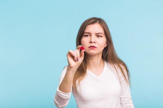 Young woman with red tablet on blue background.