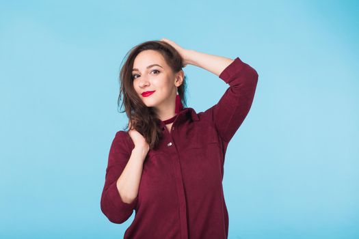 Portrait of young beautiful ginger woman with freckles cheerfuly smiling looking at camera. Isolated on pastel blue background. Copy space.