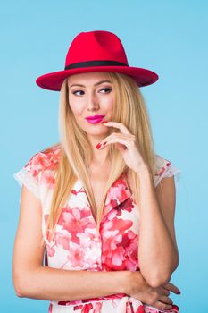 Portrait of smiling blonde woman in fashionable look on blue background. Style, fashion, summer and people concept.