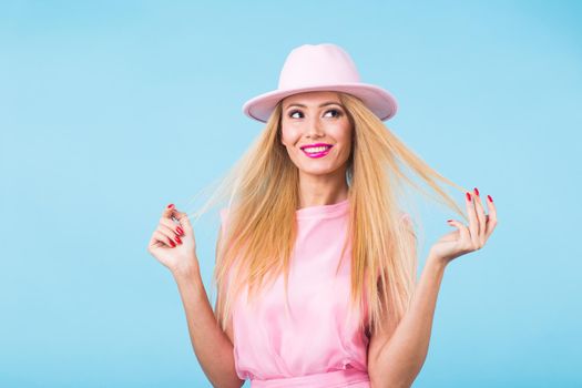 Portrait of smiling blonde woman in fashionable look on blue background. Style, fashion, summer and people concept.