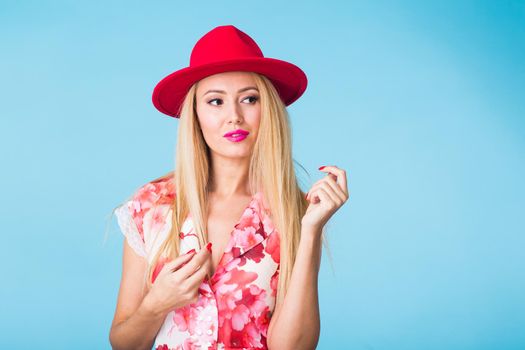 Portrait of smiling blonde woman in fashionable look on blue background. Style, fashion, summer and people concept.