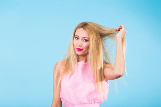 Portrait of smiling blonde woman in fashionable look on blue background. Style, fashion, summer and people concept.