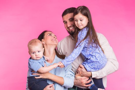 Portrait of Young Happy Mixed Race Family over pink background