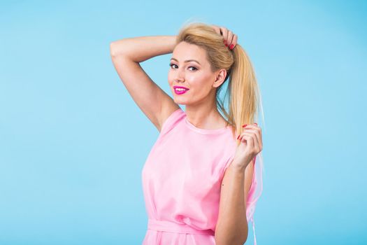 Beautiful woman with long straight blond hair. Fashion model posing at studio.