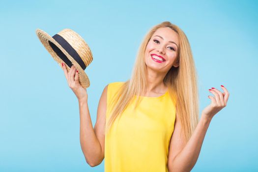 Portrait of smiling blonde woman in fashionable look on blue background. Style, fashion, summer and people concept.