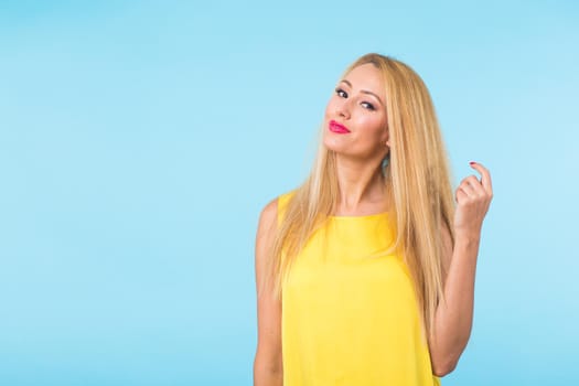 Portrait of happy cheerful smiling young beautiful blond woman on blue background.