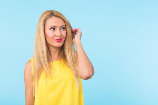 Portrait of smiling blonde woman in fashionable look on blue background. Style, fashion, summer and people concept.