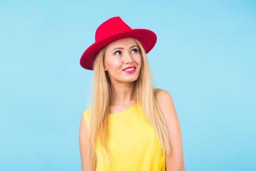 Portrait of smiling blonde woman in fashionable look on blue background. Style, fashion, summer and people concept.