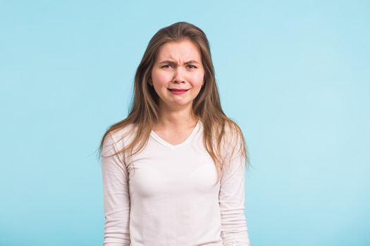 A sad beautiful woman crying on blue background