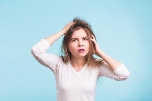 Concerned scared woman on blue background in studio