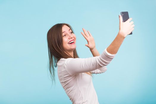 Young woman talking with friend through a video call on a smartphone. Beautiful girl having a video chat with man on mobile phone