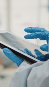 Close up of hand using dental x ray on modern tablet at oral clinic cabinet. Stomatology assistant holding device with radiography and scan technology examining teeth model for patient