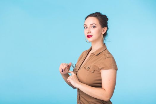 Portrait of young beautiful ginger woman with freckles cheerfuly smiling looking at camera. Isolated on pastel blue background. Copy space.