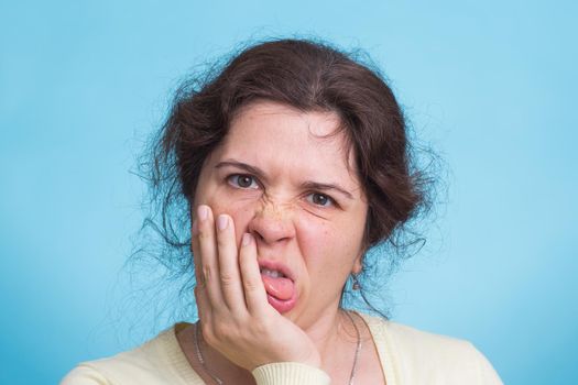 Concerned scared woman on blue background in studio