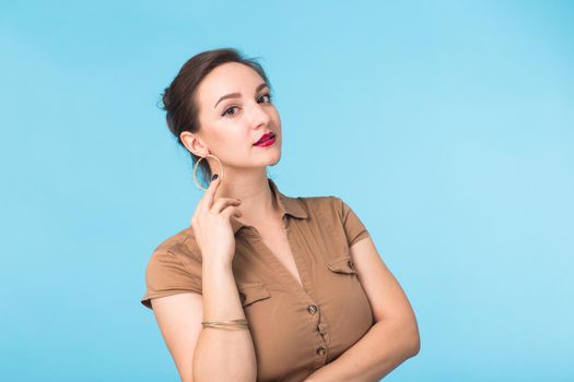 Portrait of young beautiful ginger woman with freckles cheerfuly smiling looking at camera. Isolated on pastel blue background. Copy space.