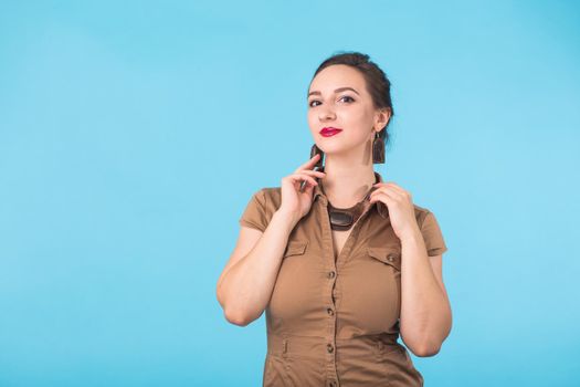 Portrait of young beautiful ginger woman with freckles cheerfuly smiling looking at camera. Isolated on pastel blue background. Copy space.