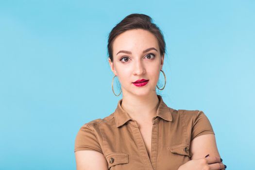 Portrait of young beautiful ginger woman with freckles cheerfuly smiling looking at camera. Isolated on pastel blue background. Copy space.