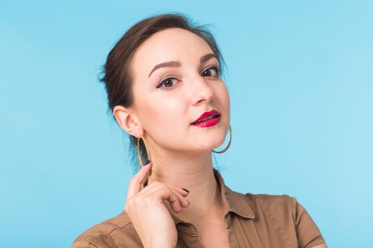 Portrait of young beautiful ginger woman with freckles cheerfuly smiling looking at camera. Isolated on pastel blue background. Copy space.