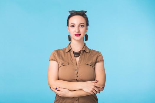 Portrait of young beautiful ginger woman with freckles cheerfuly smiling looking at camera. Isolated on pastel blue background. Copy space.