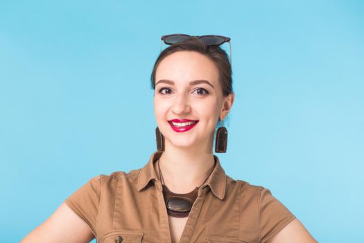 Portrait of young beautiful ginger woman with freckles cheerfuly smiling looking at camera. Isolated on pastel blue background. Copy space.