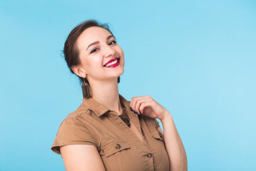 Portrait of young beautiful ginger woman with freckles cheerfuly smiling looking at camera. Isolated on pastel blue background. Copy space.