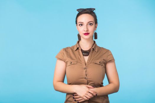 Portrait of young beautiful ginger woman with freckles cheerfuly smiling looking at camera. Isolated on pastel blue background. Copy space.