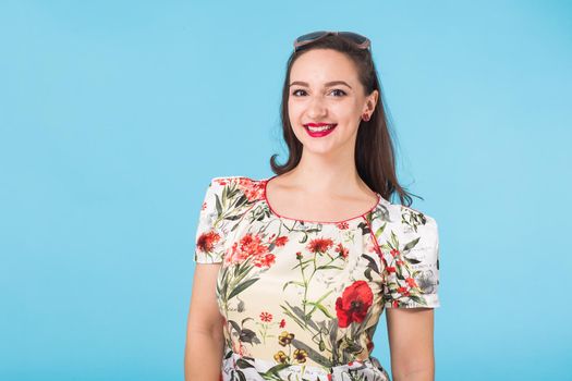 Portrait of young beautiful ginger woman with freckles cheerfuly smiling looking at camera. Isolated on pastel blue background. Copy space.