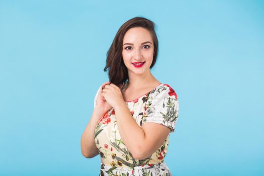 Portrait of young beautiful ginger woman with freckles cheerfuly smiling looking at camera. Isolated on pastel blue background. Copy space.