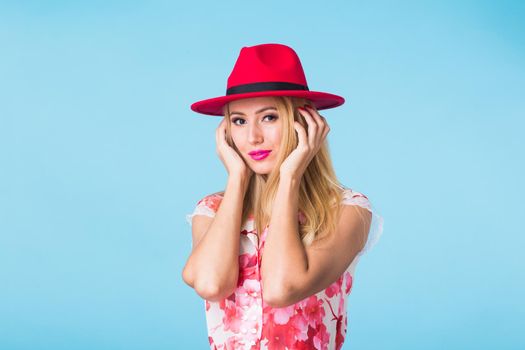 Portrait of smiling blonde woman in fashionable look on blue background. Style, fashion, summer and people concept.