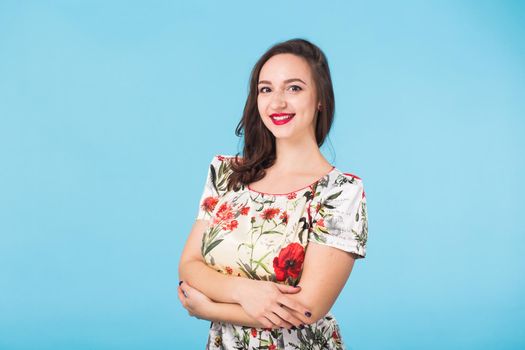 Portrait of young beautiful ginger woman with freckles cheerfuly smiling looking at camera. Isolated on pastel blue background. Copy space.