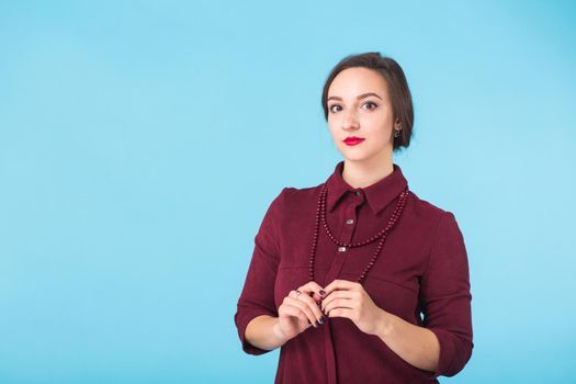 Portrait of young beautiful ginger woman with freckles cheerfuly smiling looking at camera. Isolated on pastel blue background. Copy space.