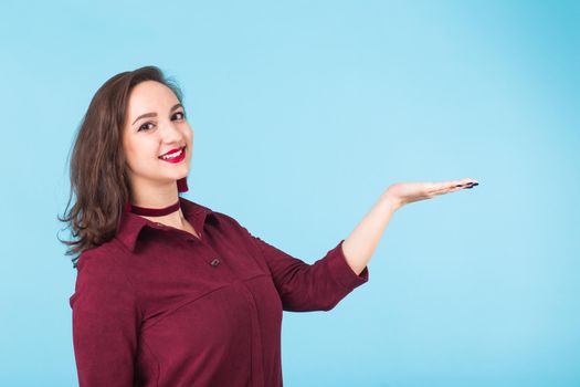 Portrait of young beautiful ginger woman with freckles cheerfuly smiling looking at camera. Isolated on pastel blue background. Copy space.