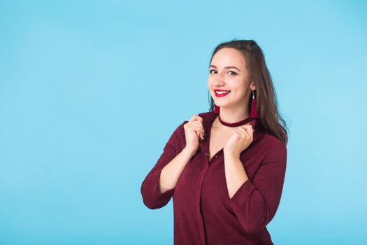 Portrait of young beautiful ginger woman with freckles cheerfuly smiling looking at camera. Isolated on pastel blue background. Copy space.