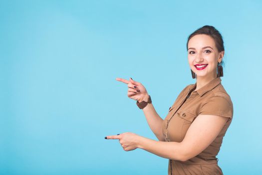 Portrait of young beautiful ginger woman with freckles cheerfuly smiling looking at camera. Isolated on pastel blue background. Copy space.