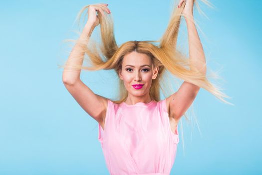 Beautiful woman with long straight blond hair. Fashion model posing at studio.