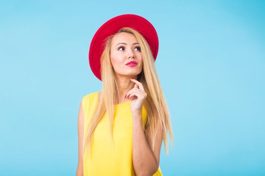 Portrait of smiling blonde woman in fashionable look on blue background. Style, fashion, summer and people concept.