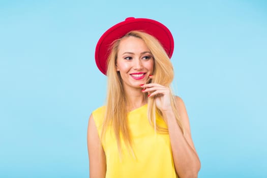 Portrait of happy cheerful smiling young beautiful blond woman on blue background.