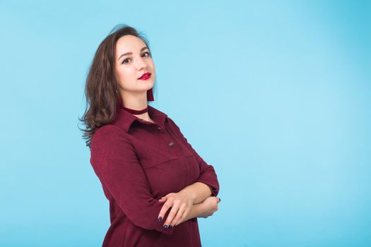 Portrait of young beautiful ginger woman with freckles cheerfuly smiling looking at camera. Isolated on pastel blue background. Copy space.