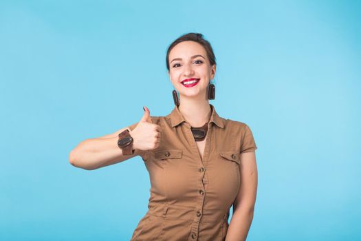 Portrait of young beautiful ginger woman with freckles cheerfuly smiling looking at camera. Isolated on pastel blue background. Copy space.