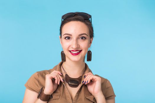 Portrait of young beautiful ginger woman with freckles cheerfuly smiling looking at camera. Isolated on pastel blue background. Copy space.