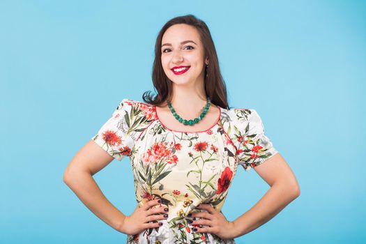 Portrait of young beautiful ginger woman with freckles cheerfuly smiling looking at camera. Isolated on pastel blue background. Copy space.