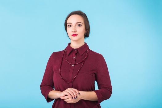 Portrait of young beautiful ginger woman with freckles cheerfuly smiling looking at camera. Isolated on pastel blue background. Copy space.