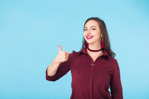 Portrait of young beautiful ginger woman with freckles cheerfuly smiling looking at camera. Isolated on pastel blue background. Copy space.