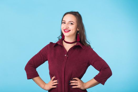 Portrait of young beautiful ginger woman with freckles cheerfuly smiling looking at camera. Isolated on pastel blue background. Copy space.