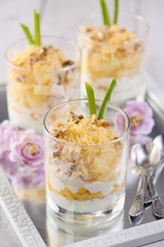 Chicken salad with pineapple, corn, seasoned with Greek yogurt, crushed nuts and grated cheese. A salad in a glass, a great idea for serving food in portions.