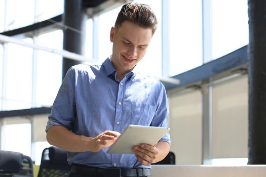 Young businessman using his tablet in the office