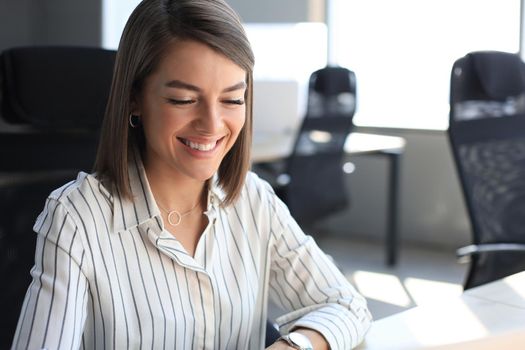 Young pretty businesswoman work on notebook computer in the bright modern office