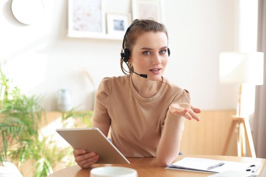 Freelance operator talking with headsets and consulting clients from home office