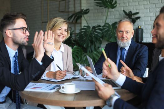 Team of business people having discussion at table in creative office