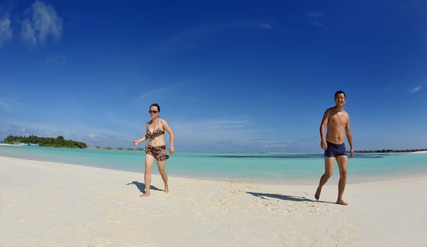 happy young asian couple have fun and romantic time at  summer on beautiful white sand beach